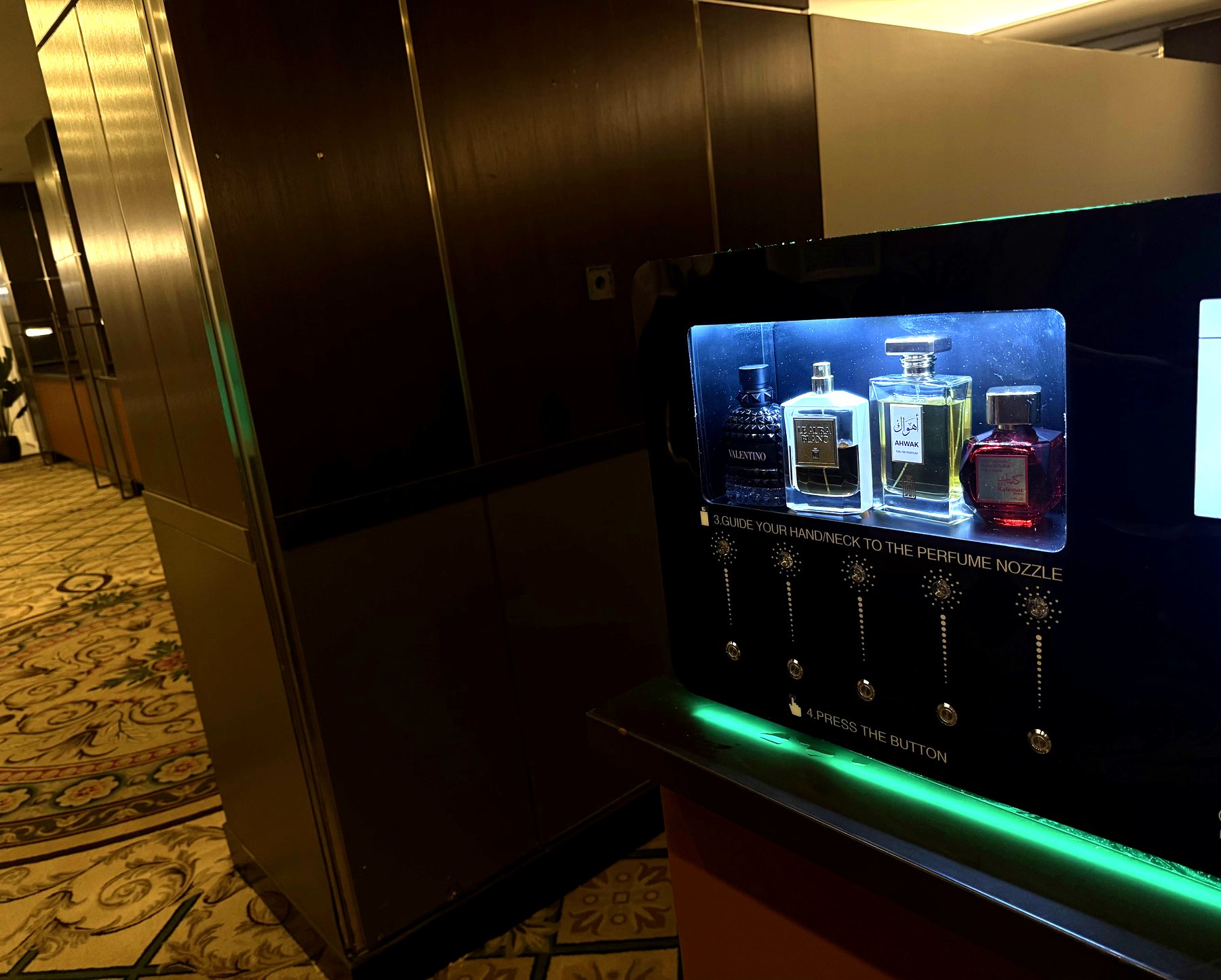 SCENTLÉ machine installed in a venue corridor, LED accent lighting glowing along the lower edge